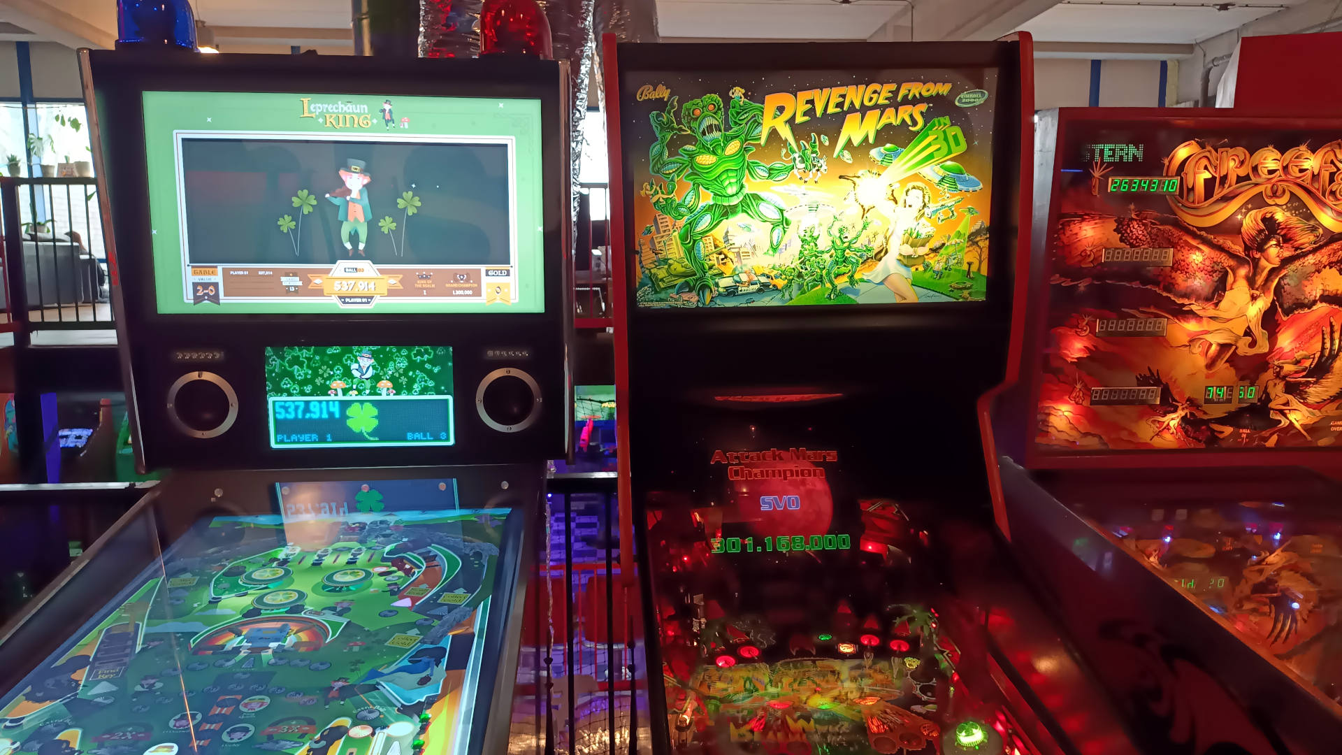 3 pinball machines next to each other: Leprechaun King on the left, Revenge from Mars in the middle and the one on the right is partially visible